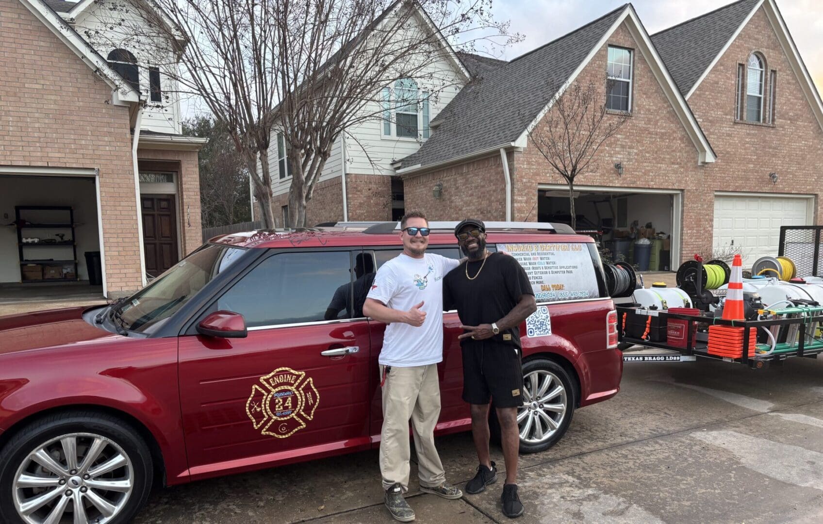 Two men standing beside a red fire department vehicle in a residential area.