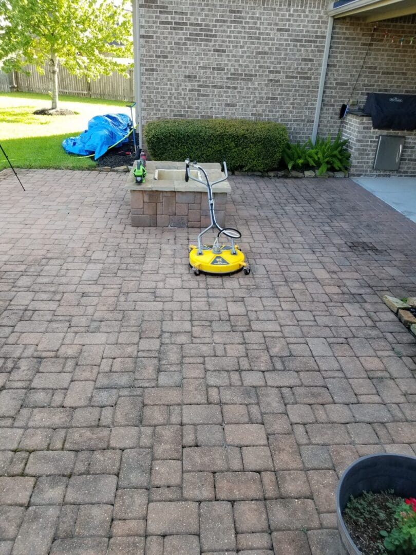Remote-controlled car racing on a brick patio with a small table.