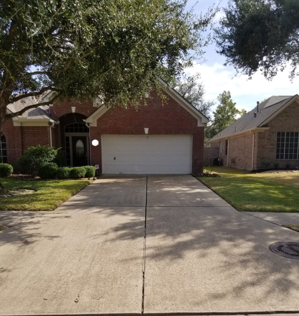 Suburban house with a clean driveway and a two-car garage.